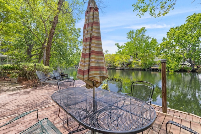 wooden terrace with outdoor dining space and a water view