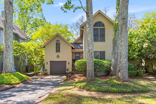 traditional home featuring a garage and aphalt driveway