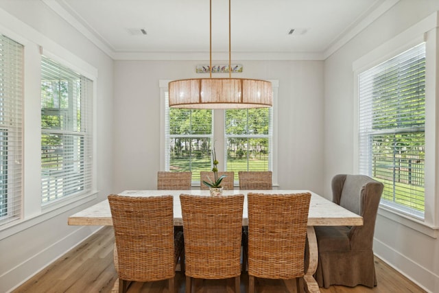 dining room featuring ornamental molding, visible vents, baseboards, and wood finished floors