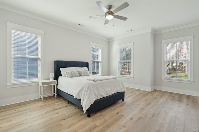 bedroom featuring baseboards, visible vents, crown molding, and light wood finished floors