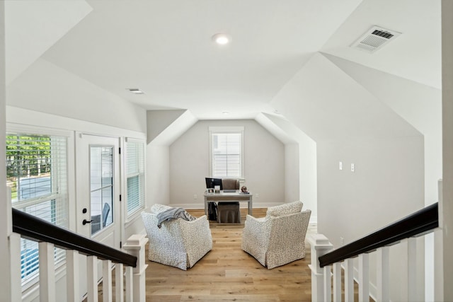 bonus room featuring vaulted ceiling, light wood finished floors, and visible vents