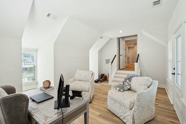 interior space featuring lofted ceiling, light wood-style flooring, and visible vents