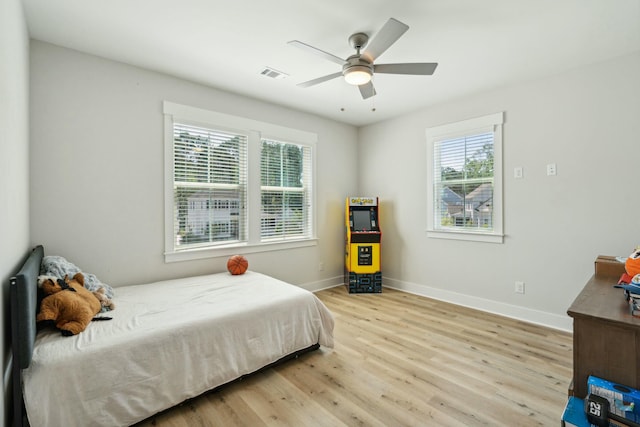 bedroom featuring a ceiling fan, baseboards, visible vents, and wood finished floors