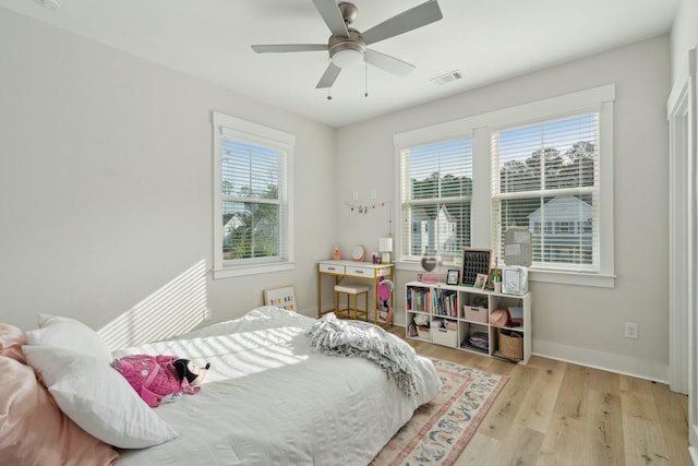 bedroom featuring a ceiling fan, baseboards, visible vents, and wood finished floors