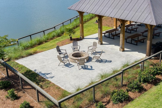 view of property's community featuring a patio, a fire pit, a water view, fence, and a gazebo