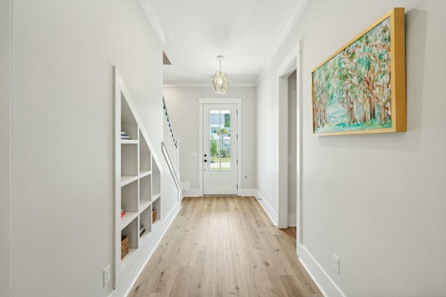 doorway featuring stairs, crown molding, baseboards, and wood finished floors