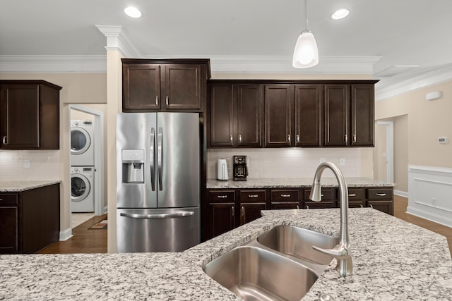 207 Brutus Ln, Summerville, SC 29485 - kitchen featuring stainless steel refrigerator with ice dispenser, a sink, stacked washer and clothes dryer, dark brown cabinets, and ornamental molding