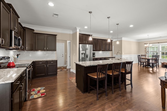 207 Brutus Ln, Summerville, SC 29485 - kitchen with appliances with stainless steel finishes, dark brown cabinetry, ornamental molding, a kitchen bar, and a sink