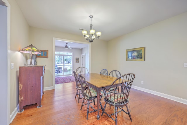 dining space with baseboards, a chandelier, and wood finished floors