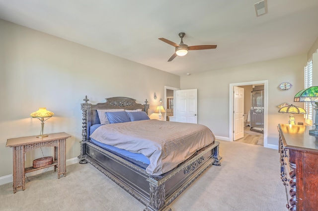 bedroom featuring baseboards, ensuite bathroom, visible vents, and light colored carpet