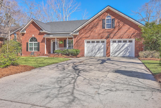 view of front facade with aphalt driveway, brick siding, roof with shingles, a porch, and a front yard