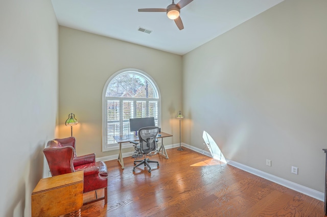 living area with a ceiling fan, baseboards, visible vents, and wood finished floors