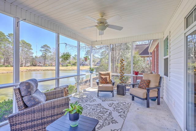 sunroom / solarium featuring a water view and ceiling fan