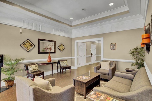 living area featuring recessed lighting, a raised ceiling, crown molding, and wood finished floors