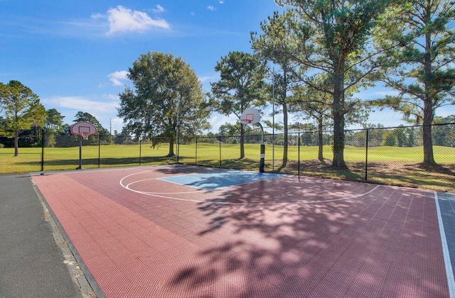 view of basketball court with community basketball court, fence, and a lawn