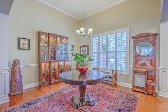 dining space with a chandelier, wood finished floors, a towering ceiling, baseboards, and ornamental molding