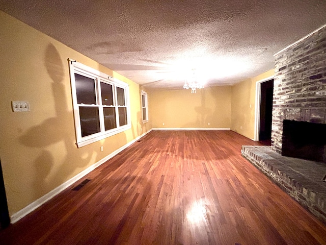 1871 Grimball Rd, Charleston, SC 29412 - unfurnished living room with wood finished floors, a brick fireplace, baseboards, a textured ceiling, and a chandelier