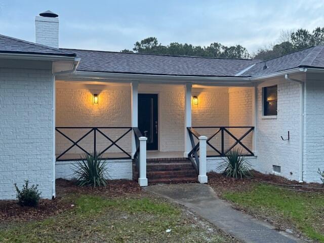 view of exterior entry featuring a porch