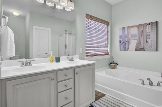 full bath with a garden tub, a sink, a shower stall, and double vanity