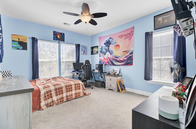 carpeted bedroom with visible vents, a ceiling fan, and baseboards