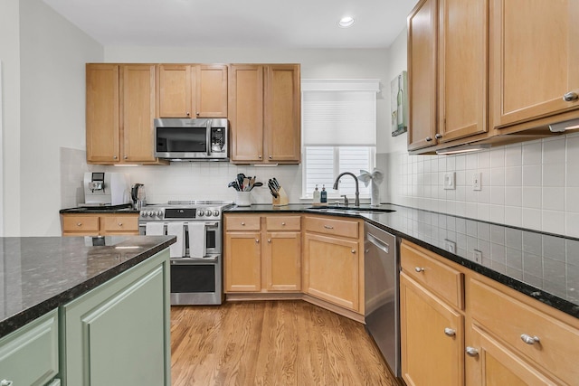 134 Etiwan Park St, Charleston, SC 29492 - kitchen with appliances with stainless steel finishes, a sink, light wood-style flooring, tasteful backsplash, and dark stone counters