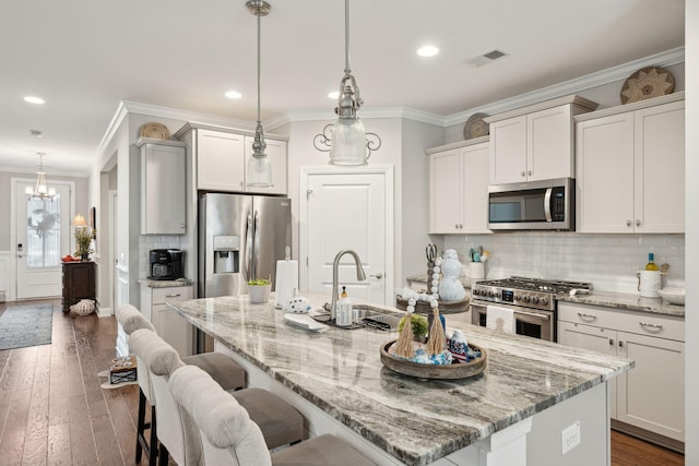 259 Camber Rd, Huger, SC 29450 - kitchen featuring stainless steel appliances, ornamental molding, a kitchen bar, a kitchen island with sink, and dark wood-style floors