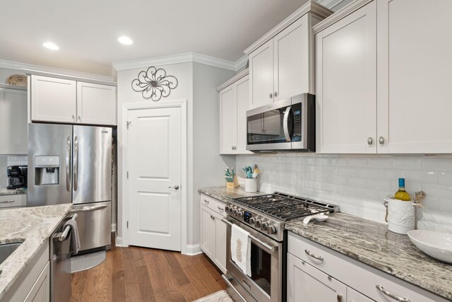 259 Camber Rd, Huger, SC 29450 - kitchen with appliances with stainless steel finishes, ornamental molding, backsplash, dark wood-style floors, and light stone countertops
