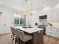 kitchen with a breakfast bar area, breakfast area, light countertops, a kitchen island, and wood finished floors