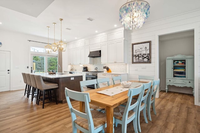 dining room with light wood-type flooring, visible vents, and a chandelier