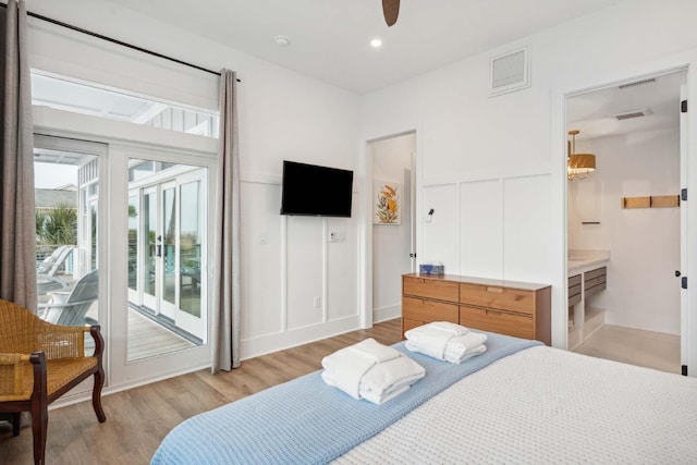 bedroom featuring light wood-style floors, access to outside, and visible vents