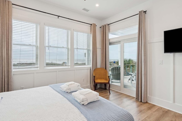 bedroom with recessed lighting, a decorative wall, visible vents, access to outside, and light wood-type flooring