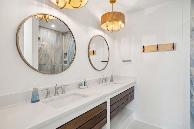 full bath featuring a chandelier, double vanity, a sink, and baseboards