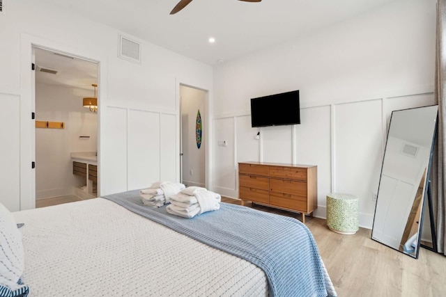 bedroom with a wainscoted wall, recessed lighting, visible vents, a decorative wall, and light wood-type flooring