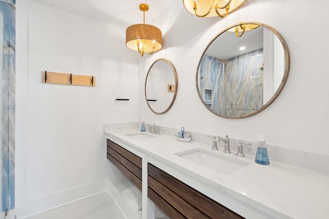 bathroom with double vanity, tile patterned flooring, a sink, and a marble finish shower