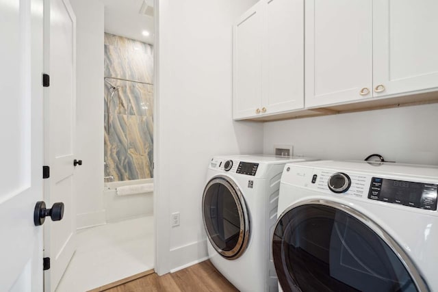 washroom featuring light wood-type flooring, independent washer and dryer, cabinet space, and baseboards