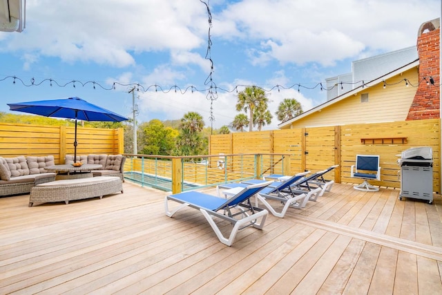 wooden deck with area for grilling and an outdoor living space