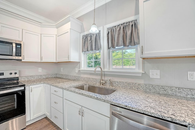 kitchen with crown molding, appliances with stainless steel finishes, a sink, and white cabinetry