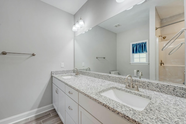 bathroom with baseboards, a sink, toilet, and wood finished floors