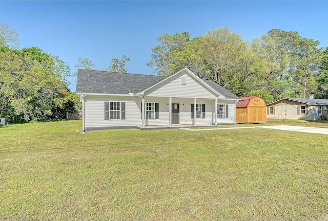 view of front facade with a shingled roof, a porch, an outdoor structure, a storage unit, and a front lawn