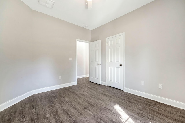 unfurnished bedroom with visible vents, baseboards, and dark wood-style floors