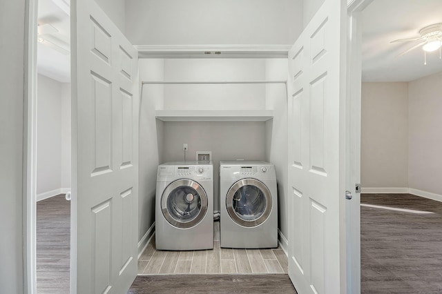 laundry room with washer and clothes dryer, laundry area, wood finished floors, and baseboards
