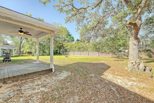 view of yard with fence and ceiling fan