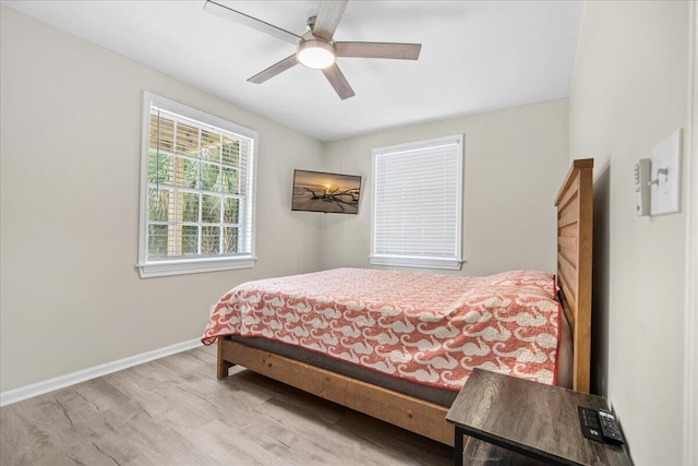 bedroom featuring baseboards, wood finished floors, and a ceiling fan