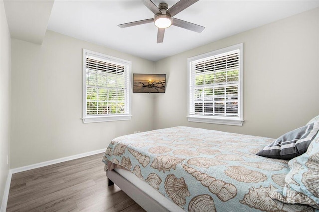 bedroom featuring wood finished floors, baseboards, and ceiling fan