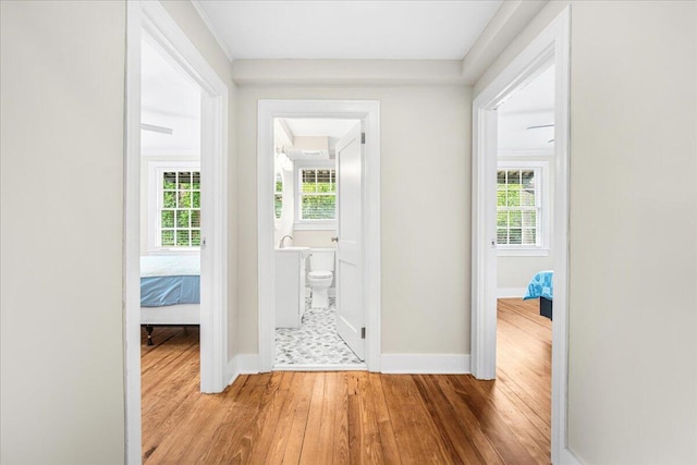 hallway featuring wood finished floors and baseboards