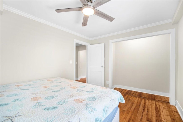 bedroom featuring wood finished floors, crown molding, baseboards, and ceiling fan