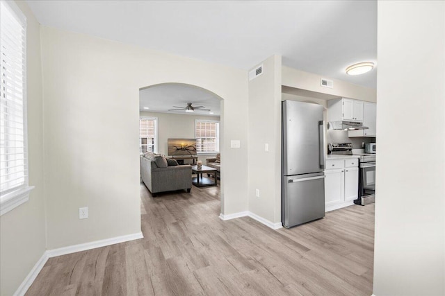 kitchen featuring stainless steel appliances, light wood-style flooring, ceiling fan, and under cabinet range hood