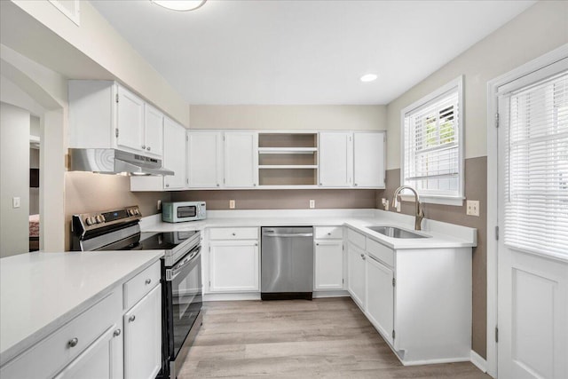 kitchen featuring appliances with stainless steel finishes, a sink, under cabinet range hood, open shelves, and white cabinetry