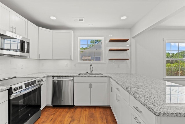 1430 E Montague Ave, North Charleston, SC 29405 - kitchen with stainless steel appliances, a sink, a peninsula, decorative backsplash, and dark wood-style flooring