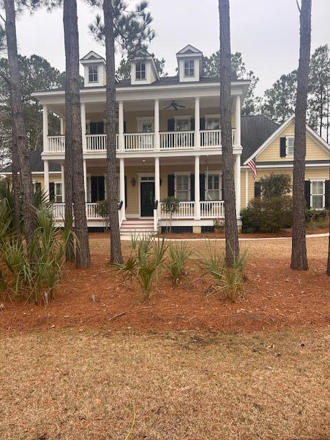 view of front facade featuring covered porch, ceiling fan, and a balcony